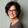 Retrato de Clara García, una mujer sonriente de unos 40 años, con cabello oscuro y gafas.